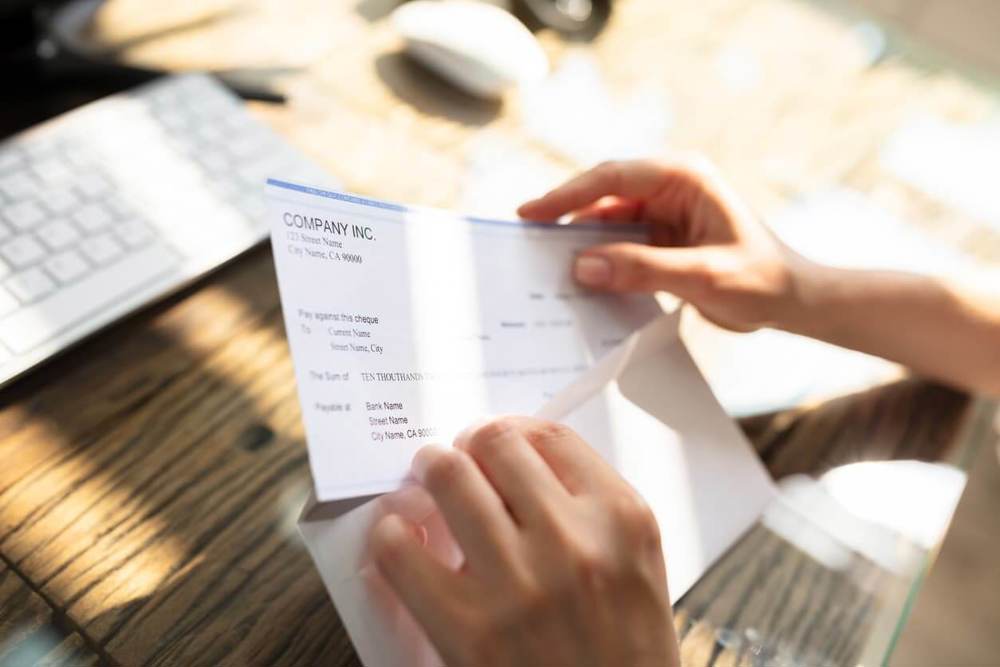 Person putting letter in envelope